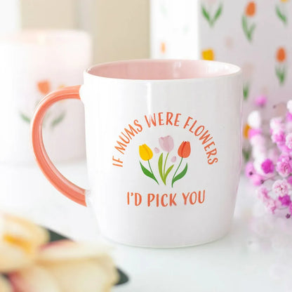 White mug with floral design and text on a blurred floral background