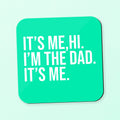 a square coaster with the text 'its me, hi, I'm the dad, its me' text on a teal background