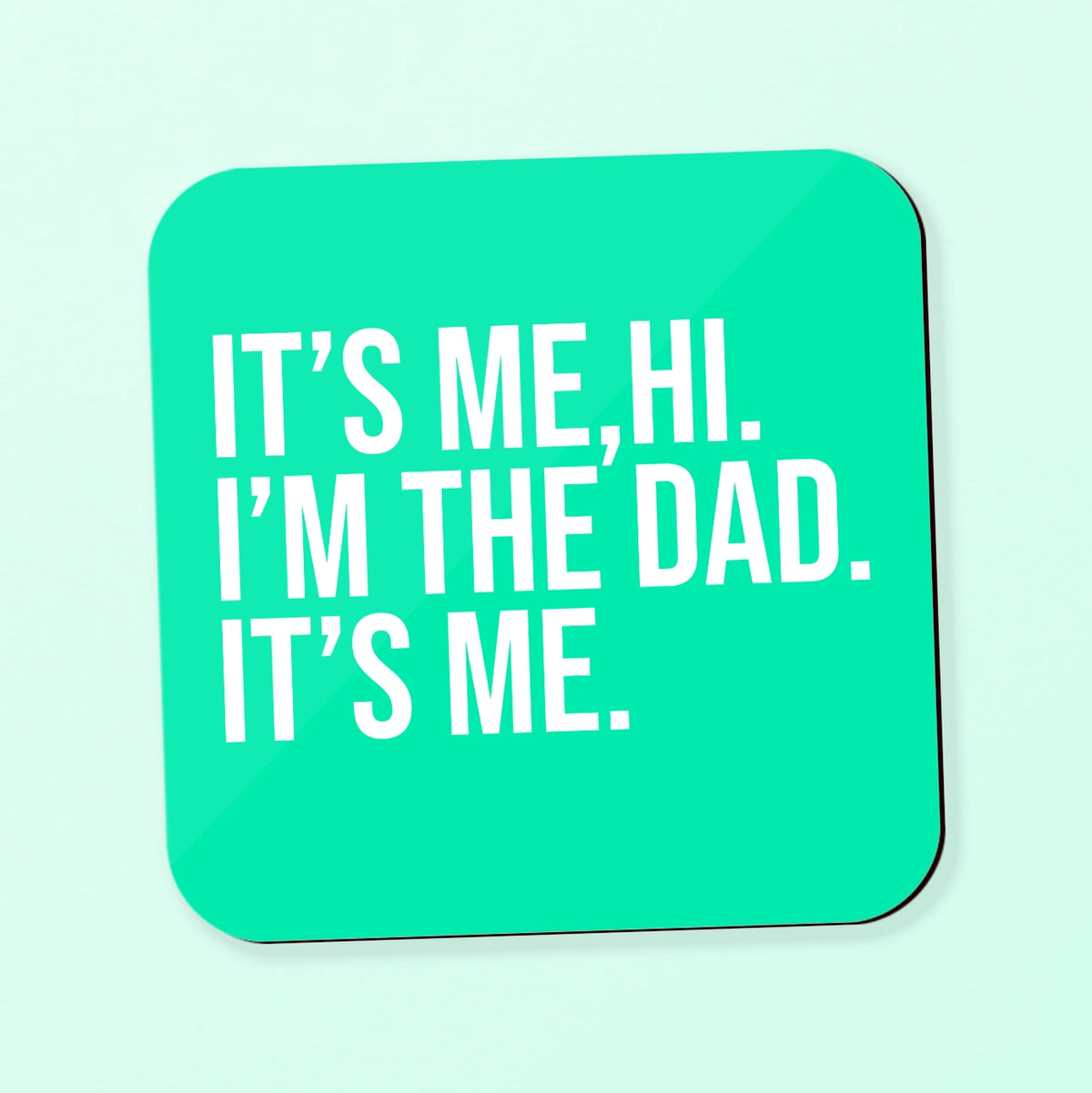a square coaster with the text 'its me, hi, I'm the dad, its me' text on a teal background