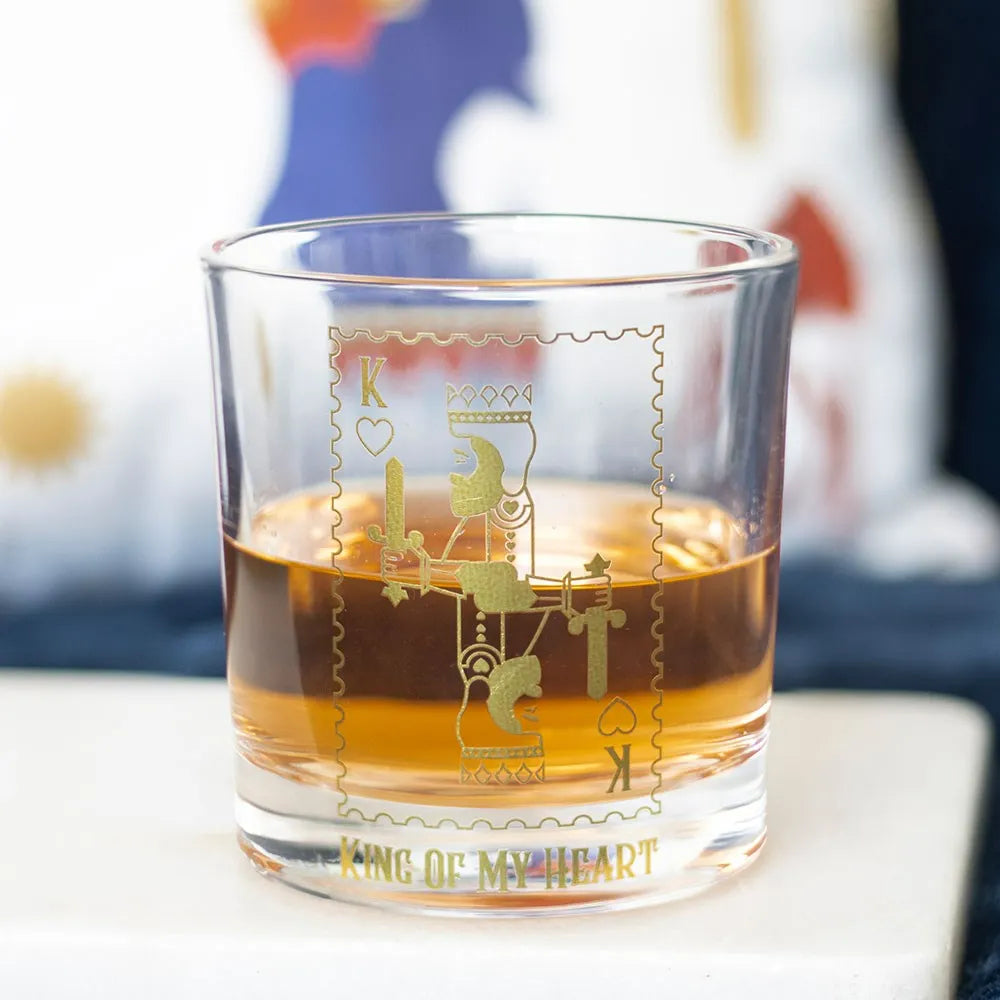 Glass with gold design and 'King of My Heart' text, filled with a liquid.