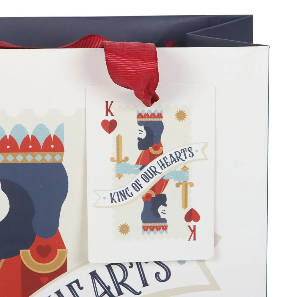 gift tag on bag with a king design and red ribbon on a white background