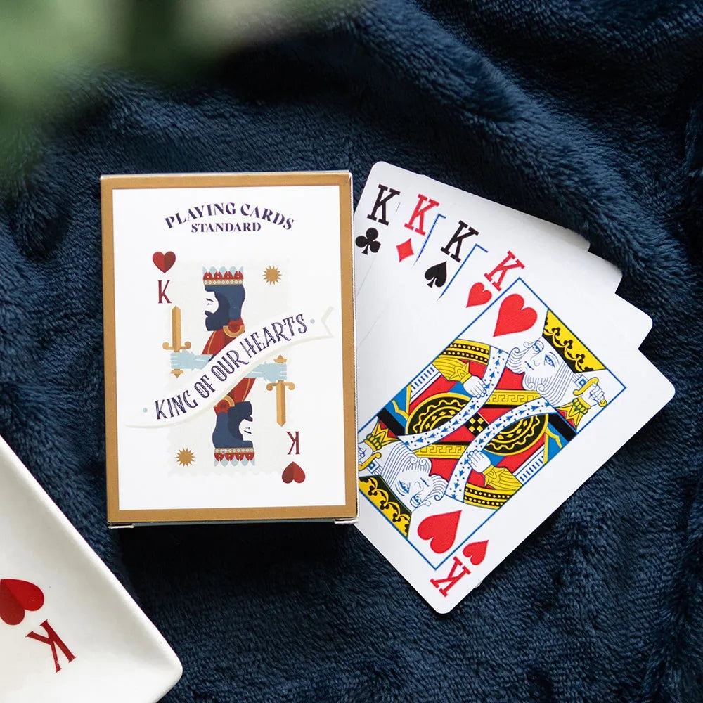 Playing cards with King of Hearts design on a dark blue fabric background