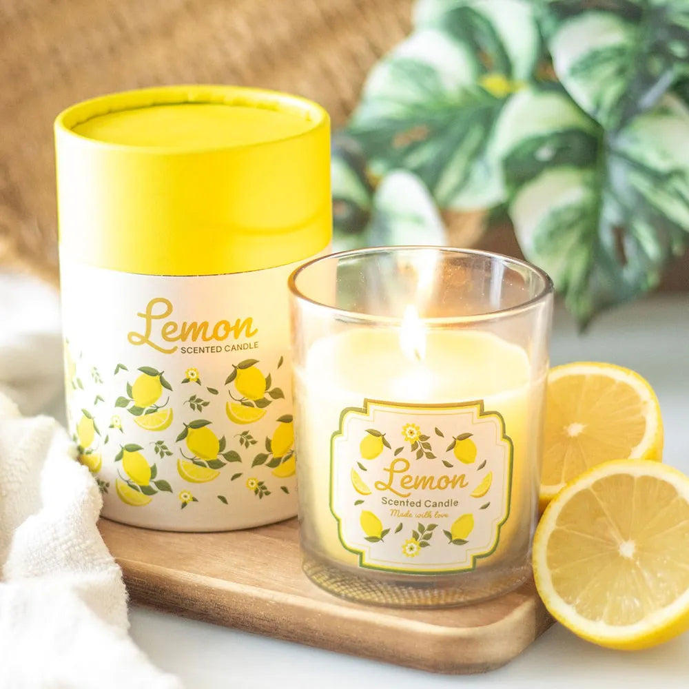 Lemon scented candle with wooden lid with packaging and lemons on a wooden tray