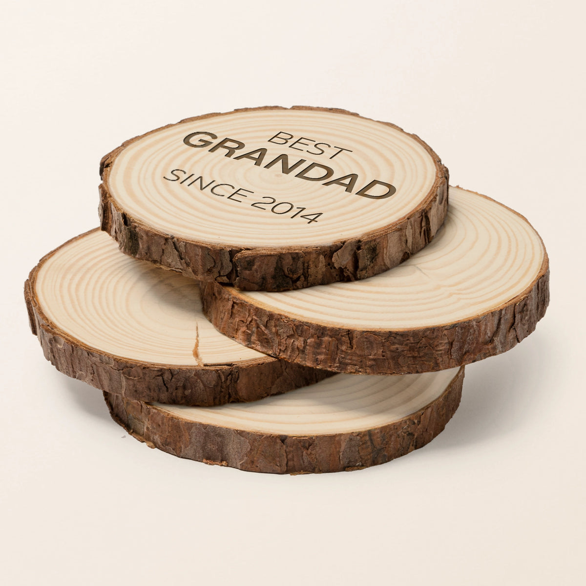 a stack of log slice coasters with bark edges with best [person] since [year] laser engraved on top