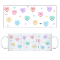 white mug with pastel-coloured love heart designs on a white background