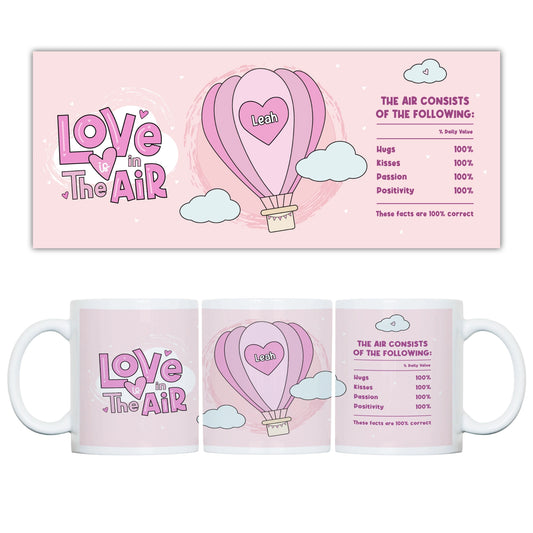 Mug with 'Love is in the Air' design featuring a hot air balloon and text on a pink background.