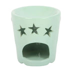 Mint green ceramic oil burner with star cutouts on a white background