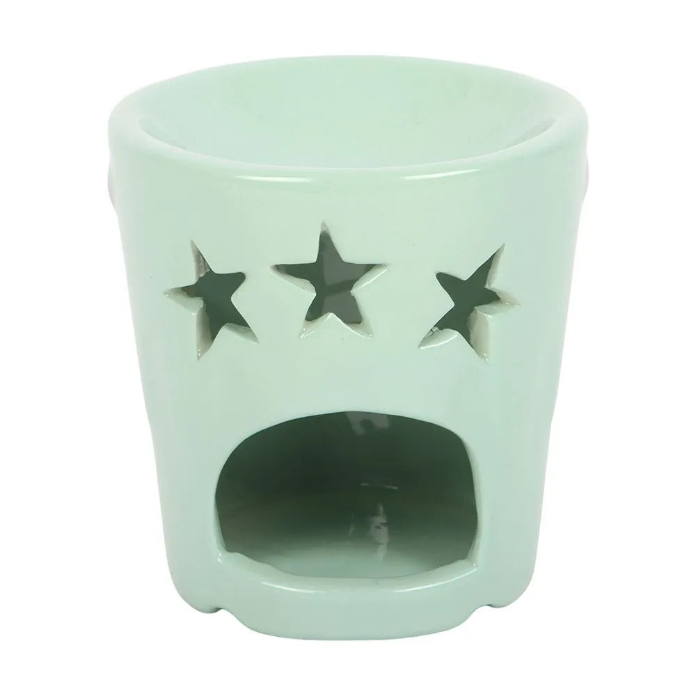 Mint green ceramic oil burner with star cutouts on a white background