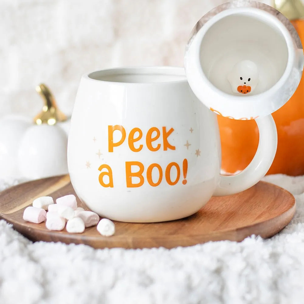 a round white mug printed with 'peek a boo' with a 3D ghost inside.
