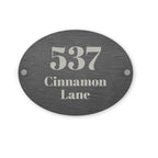 Slate oval house number sign with '537 Cinnamon Lane' text on a white background