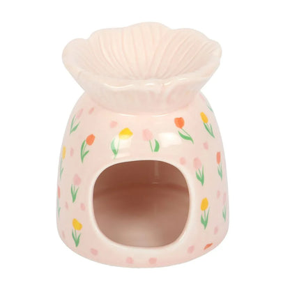Pink ceramic warmer with floral design on a white background
