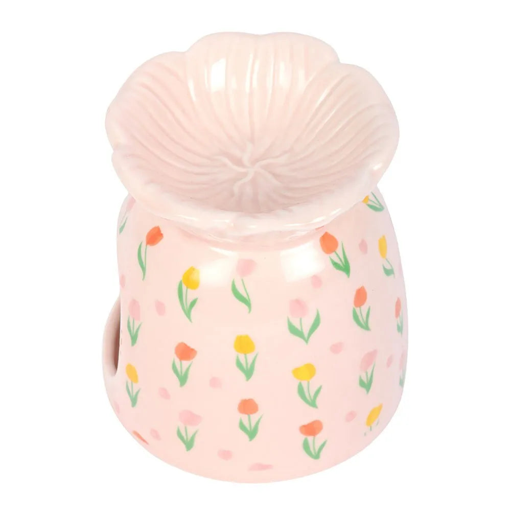 Pink oil burner with floral pattern and shell-like lid on a white background