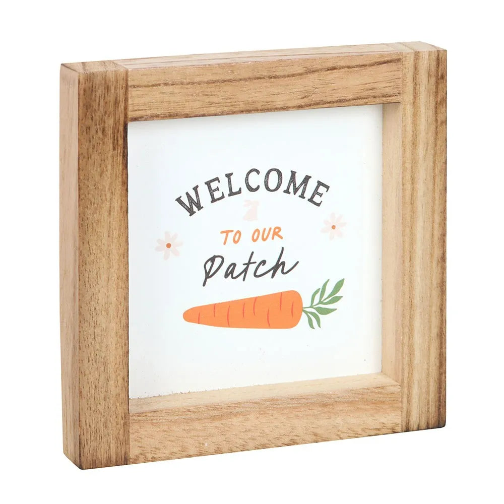 Wooden-framed sign with 'Welcome to our Patch' text and carrot illustration on a white background