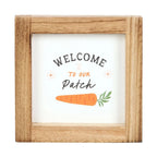 Wooden-framed sign with 'Welcome to our Patch' text and a carrot illustration on a white background.