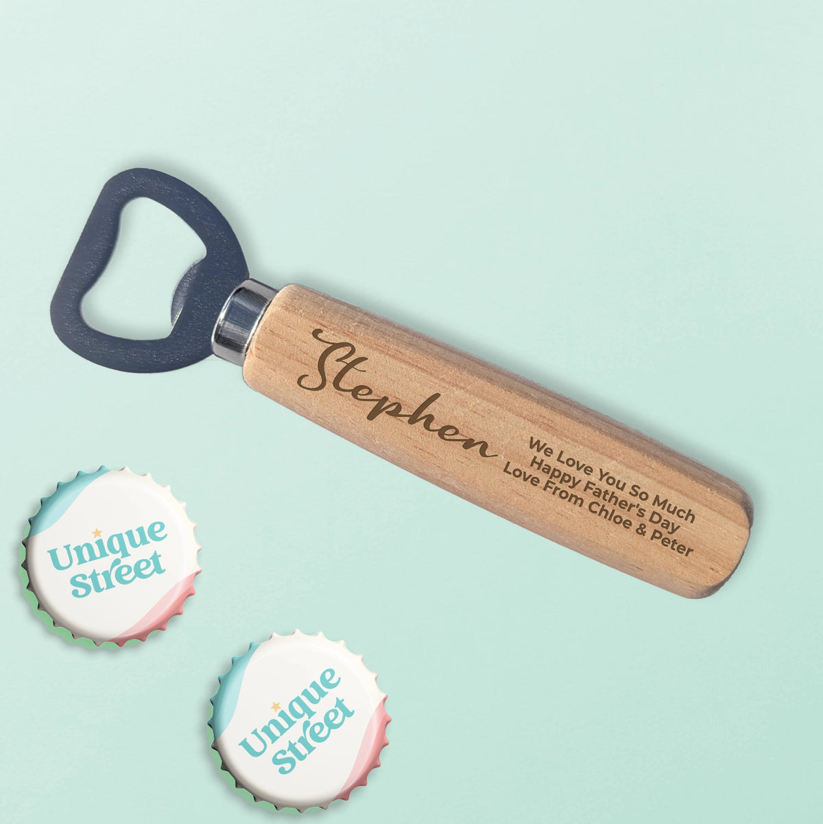 Personalized wooden bottle opener with engraved name and message on a light mint background, with two decorative 'Unique Street' bottle tops