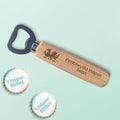 A personalized wooden bottle opener with engraved  text and Welsh dragon, shown on a pale mint background with two 'Unique Street' branded bottle cap stickers.