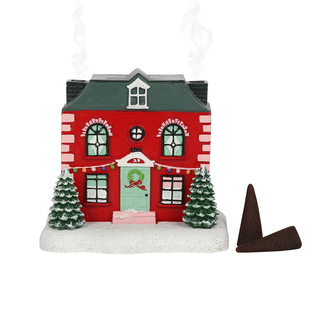 A Christmas-themed house incense cone burner with decorative details, also showing a brown incense cones at its side.